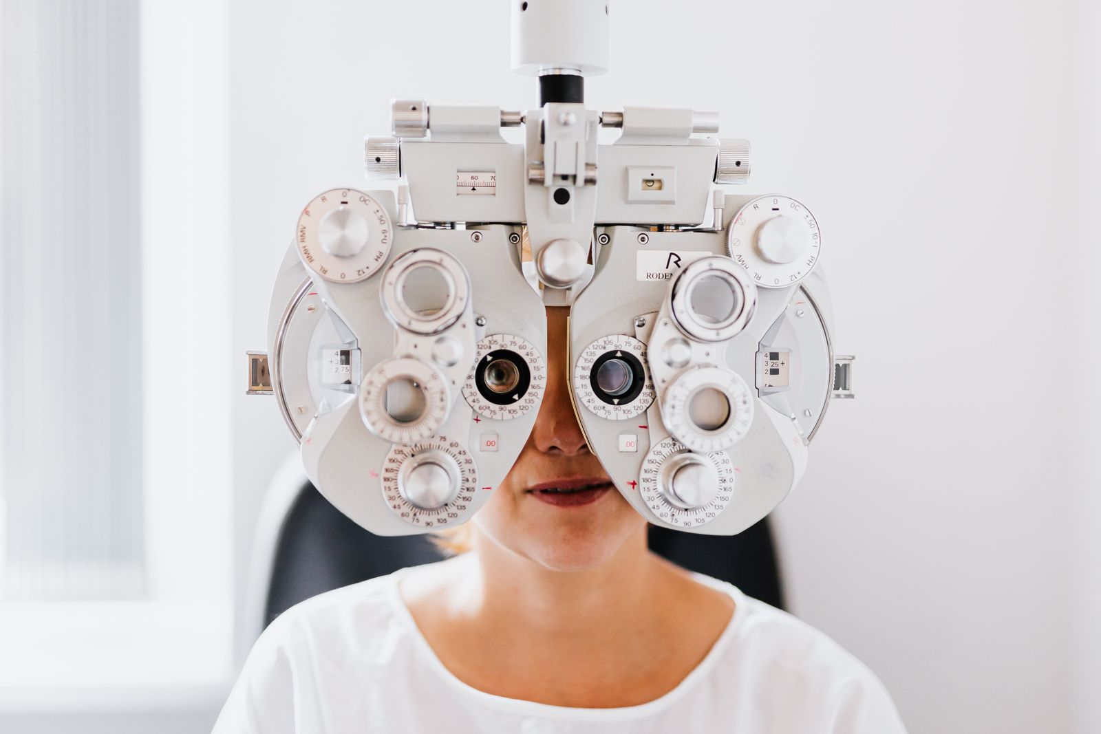 Patient undergoing an eye exam with a phoropter in a modern clinic