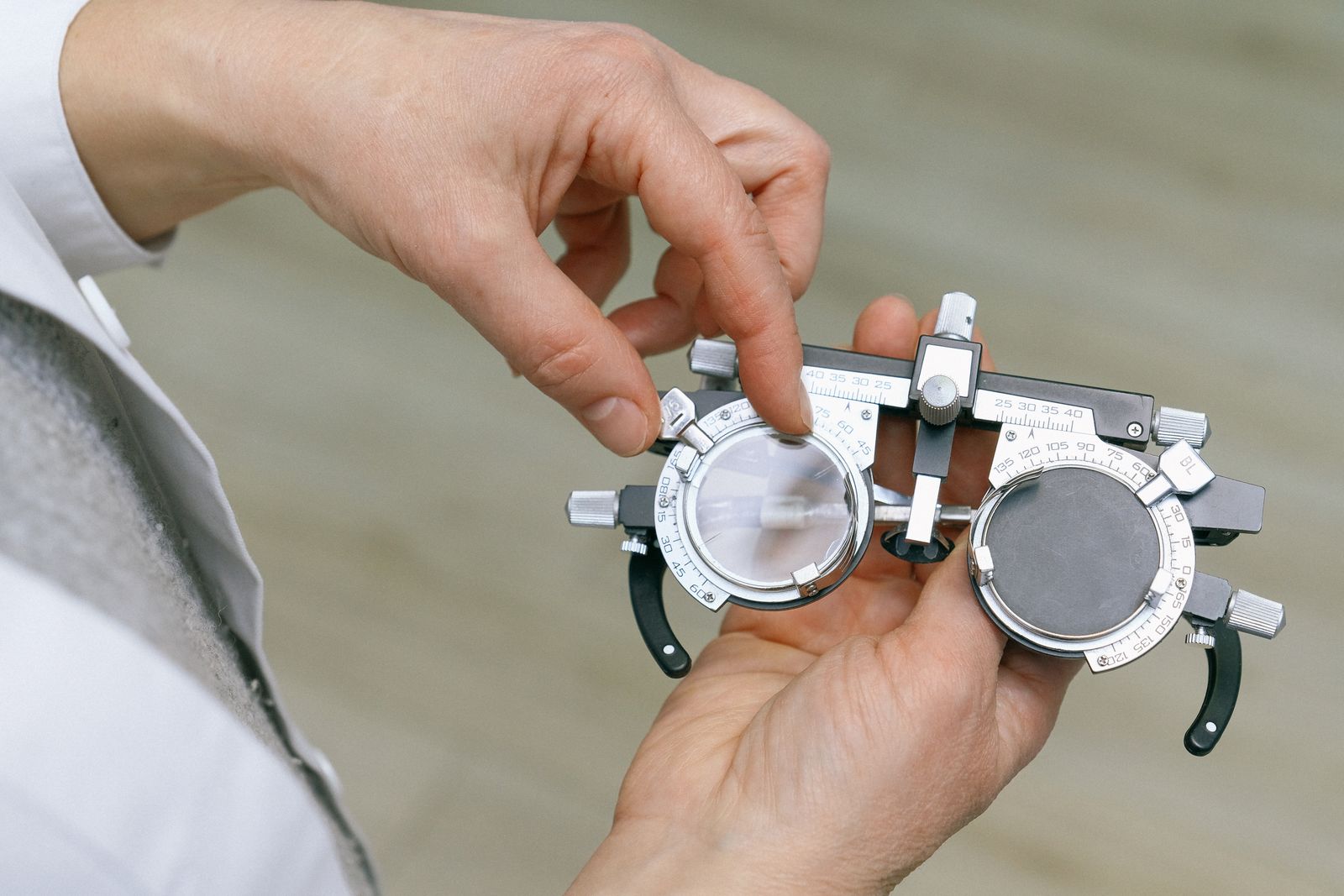 Optometrist using trial lenses to measure a patient's eye during an exam