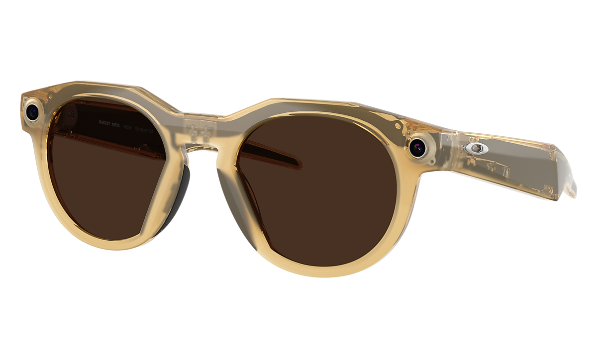 Oakley Meta HSTN smart glasses in a translucent amber frame with brown lenses