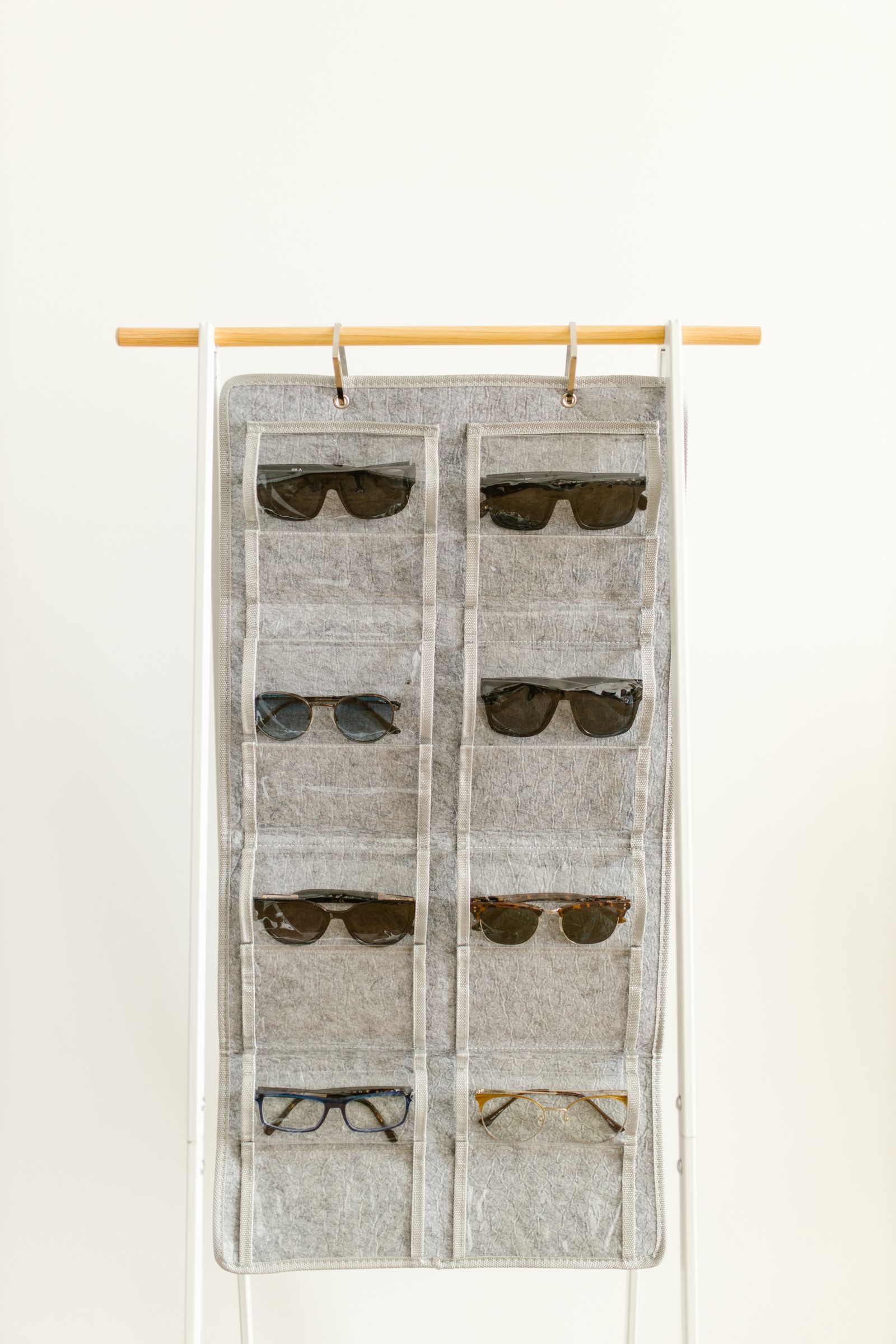 Sunglasses and eyeglasses arranged in a hanging fabric organizer